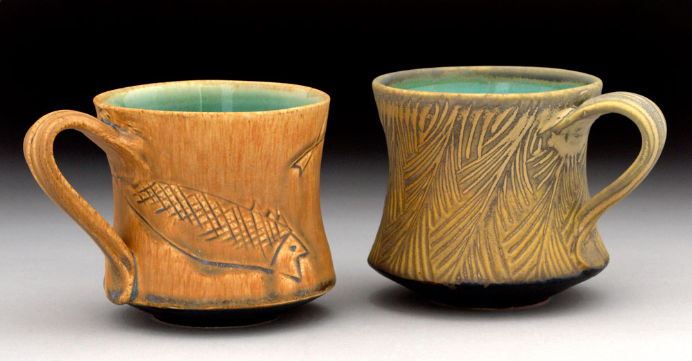 two gold glazed mugs with turquoise glaze on the inside